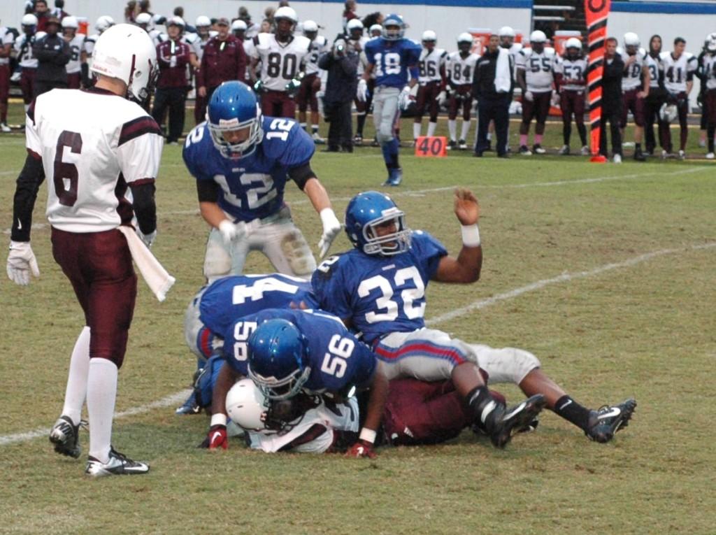 Sophomore linebacker Brandon Medlin, #32, and sophomore defensive lineman Eric Williamston, #56, swarm a Wolverine ball carrier in the 48-14 rout. 