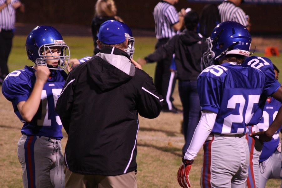Coach Glenndon Dillard confers with #15 defensive back Andrew Brown and #25 defensive back Mitchell Glover during the final game of the season against Enloe. 