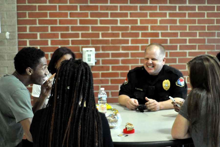 SRO Rob Woyicki interacts with senior Isaiah Jones (left) and other students during a lunch period March 28. One of the benefits of having a school resource officer has been cited in creating a positive relationship between students and police. 