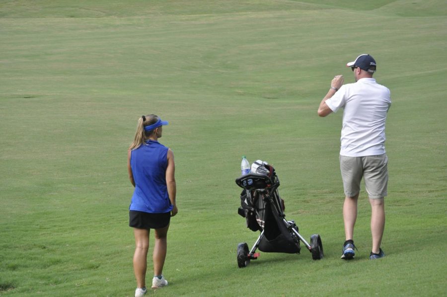 Senior Carter Day consults with coach Jeremiah Mattingly on her approach shot during the Sept. 4 match at Heritage. 