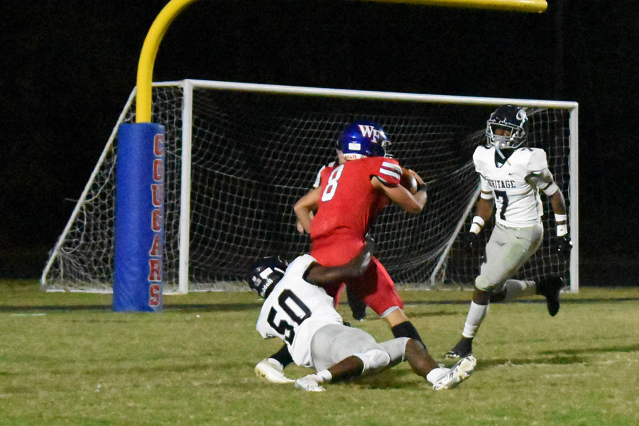 Mike DiPasquale RB fights off a Heritage Defender. The Cougars defeated the Huskies 48 to 14 in the Oct. 14 matchup. 