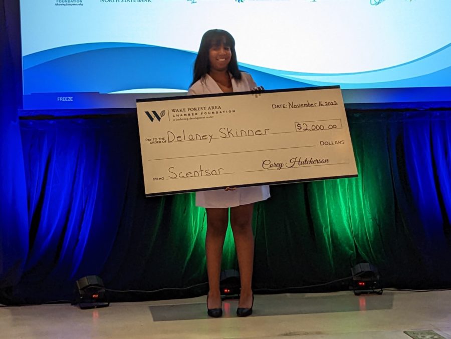 Delaney Skinner (pictured) holds check presented by the Wake Forest Chamber Foundation for her company, Scentsor. 