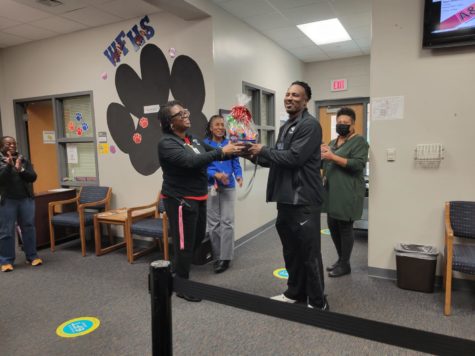 Assistant Principal Cynthia Simons, left, recognizes coach Jamie Holland, right, in the main office for his selection as the 2022-23 Instructional Teacher Assistant of the Year. 